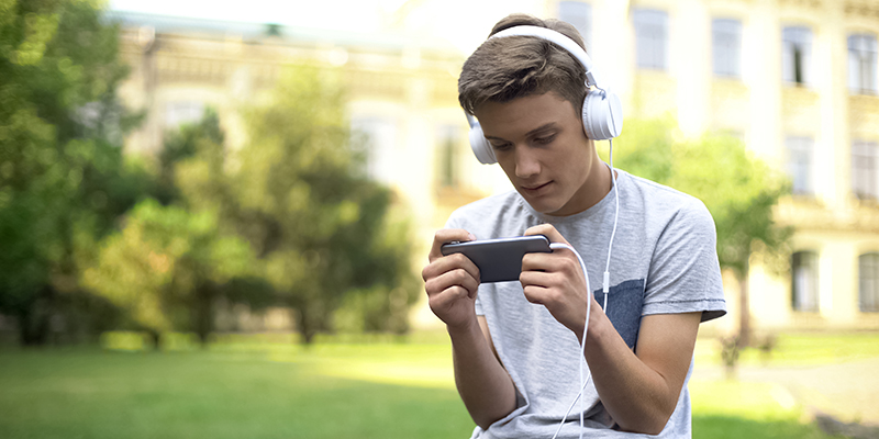 Scholier zit te gamen op zijn smartphone