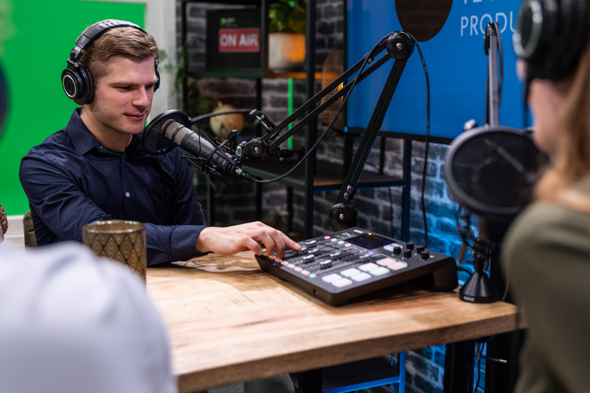 Podcasttechnicus bedient audiomixer tijdens opname in professionele studio